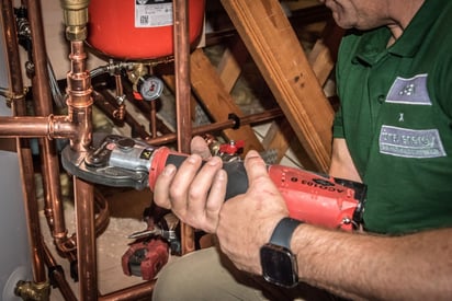 Man installing an expansion vessel to a heating system